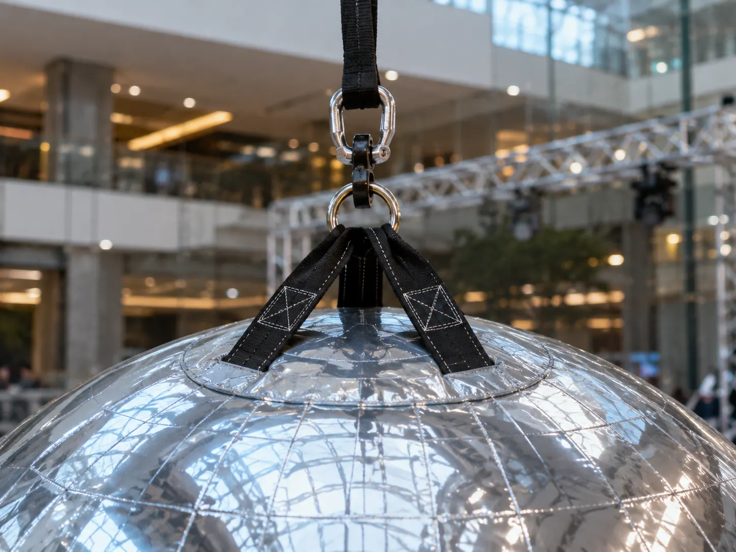 Close-up of reinforced hanging straps and anchor hardware on an inflatable mirror ball