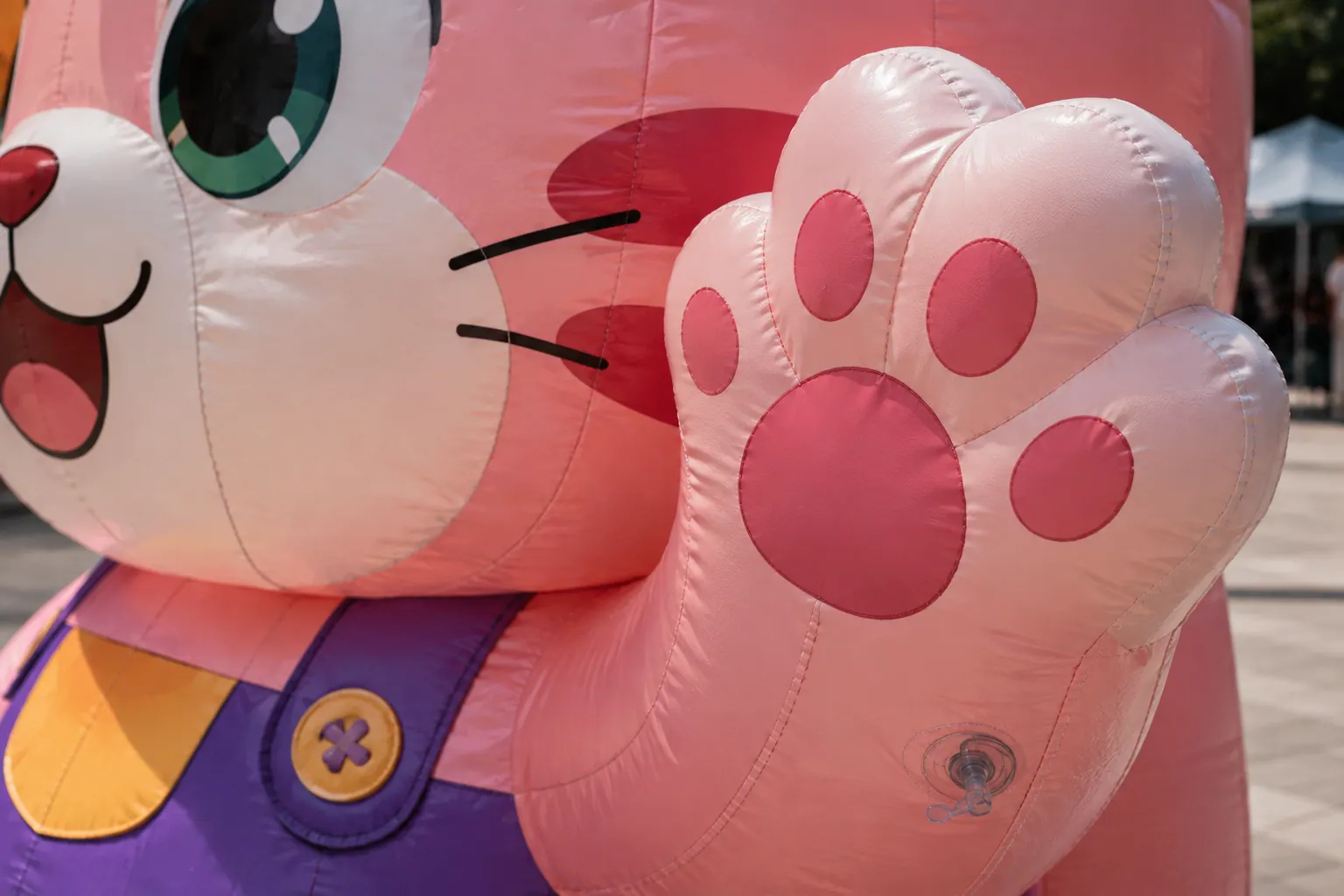 Close-up of reinforced seams, printed details and inflation valve on a custom inflatable cat mascot