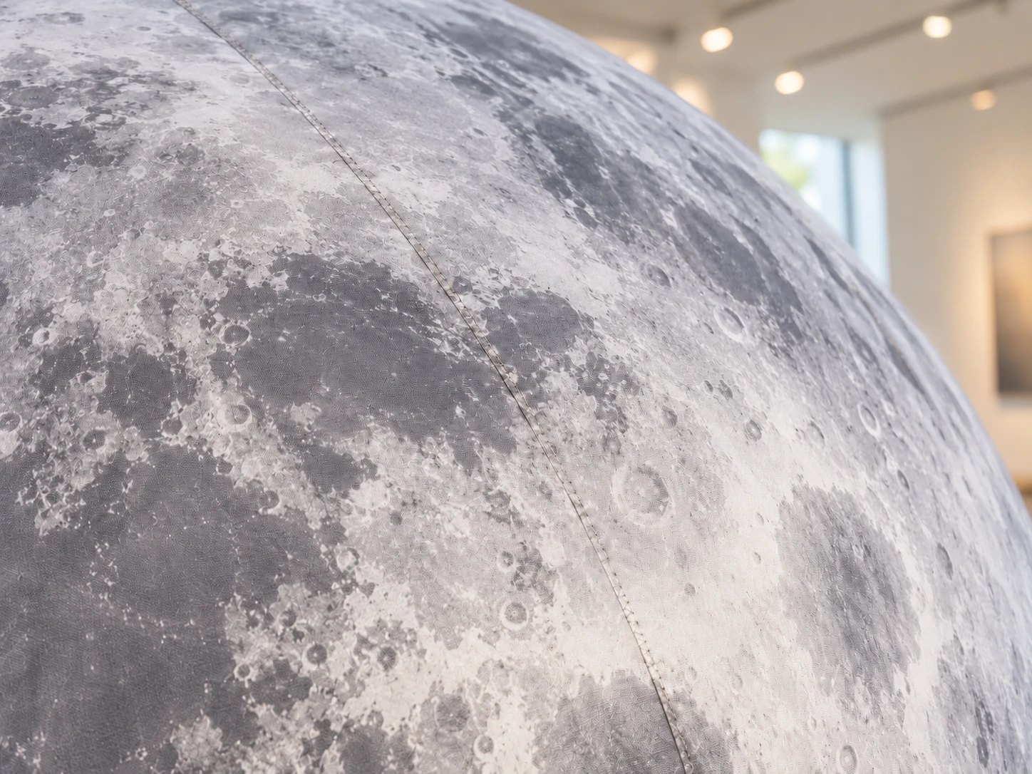 Close-up concept of flat lunar printing, woven fabric and a sewn panel seam on an inflatable moon