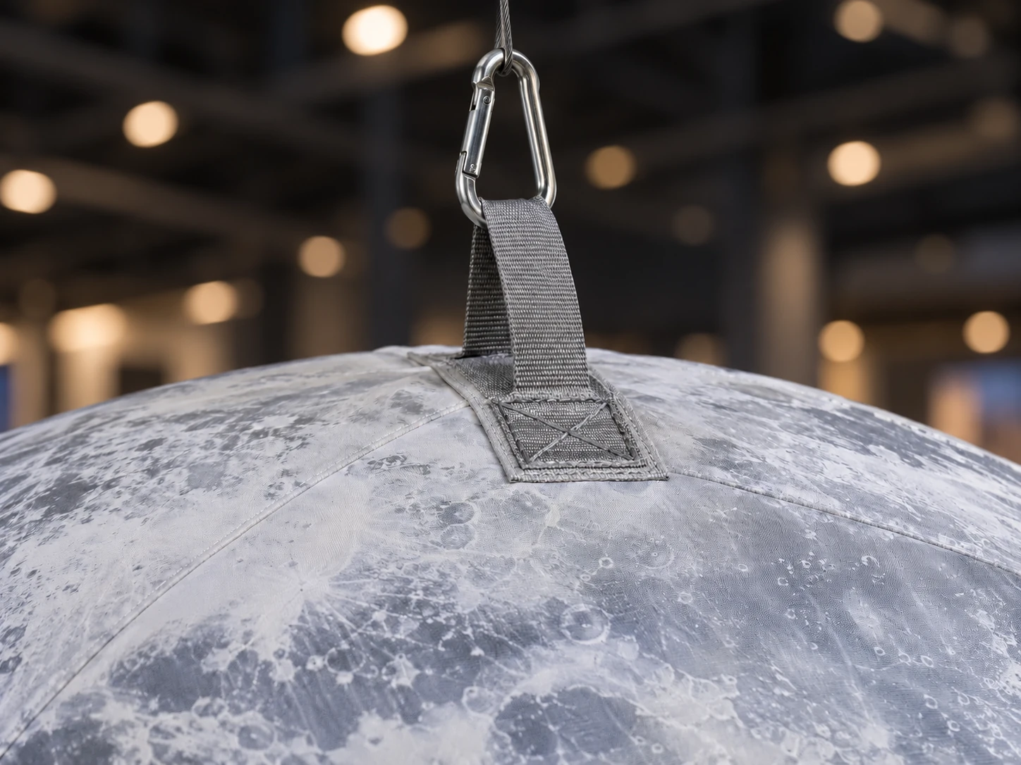Illustrative sewn reinforcement tab and suspension connection on lunar-printed inflatable fabric